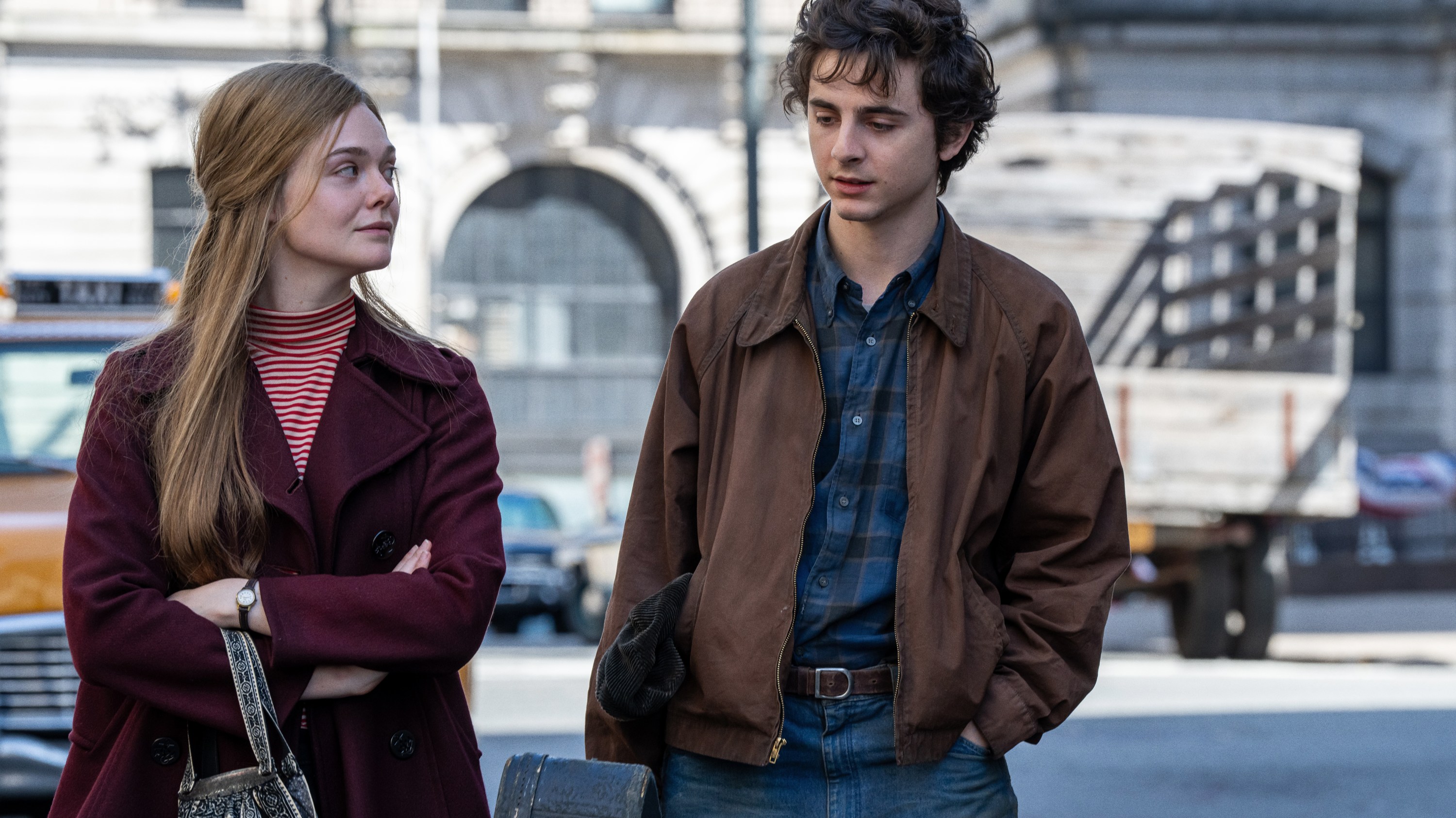 Elle Fanning and Timothee Chalamet walking on street in 'A Complete Unknown'