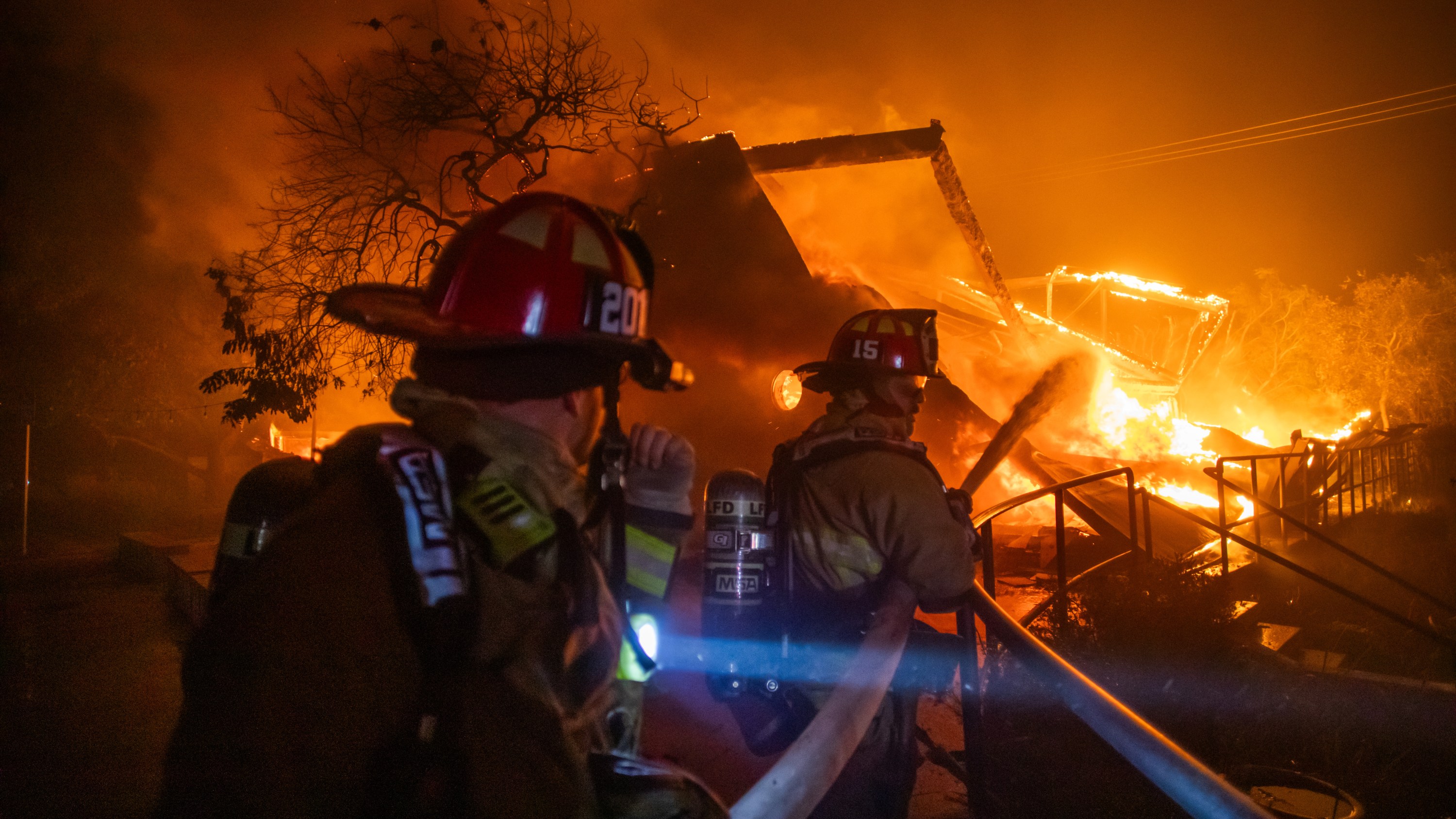 Firefighters fight the flames from the Palisades Fire burning the Theatre Palisades.